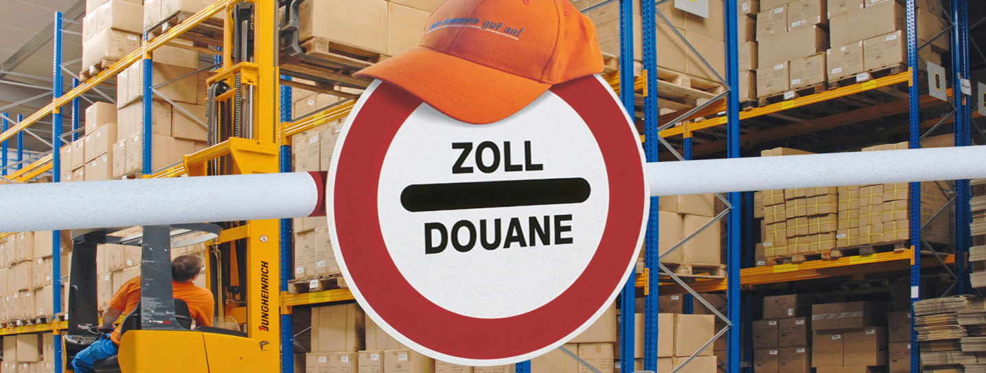 In front of the viewer is a barrier with a sign (ZOLL - DOUANE). It is round. On it lies a Rüdinger cap. In the background is a full shelf warehouse, and you can see an employee on a forklift.